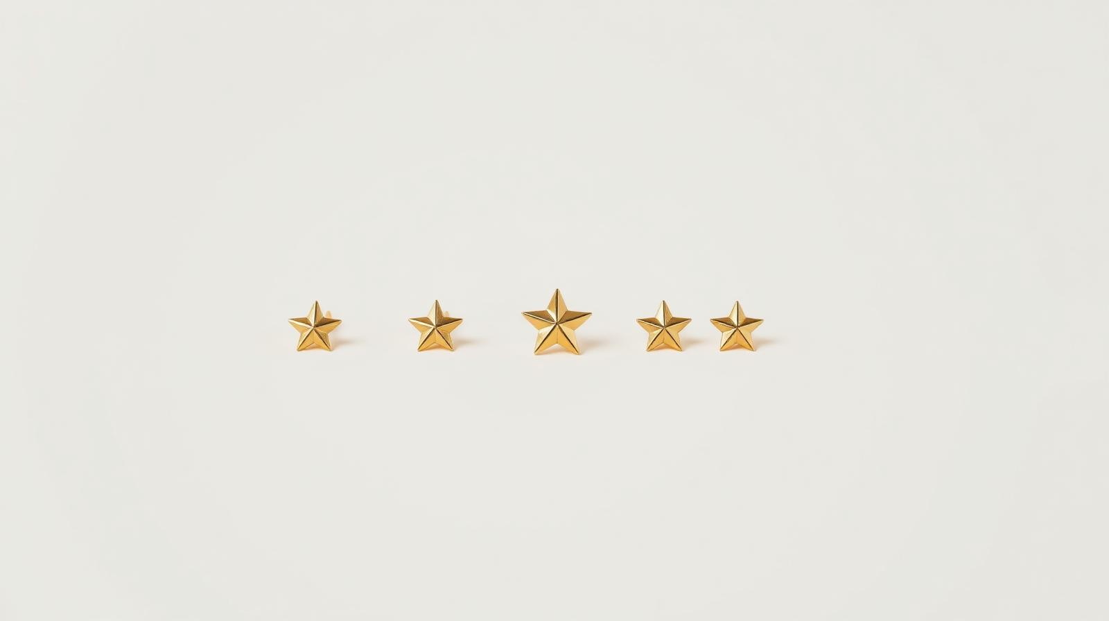 Five gold metallic stars arranged in a row on a soft neutral background — representing a 5-star Google review